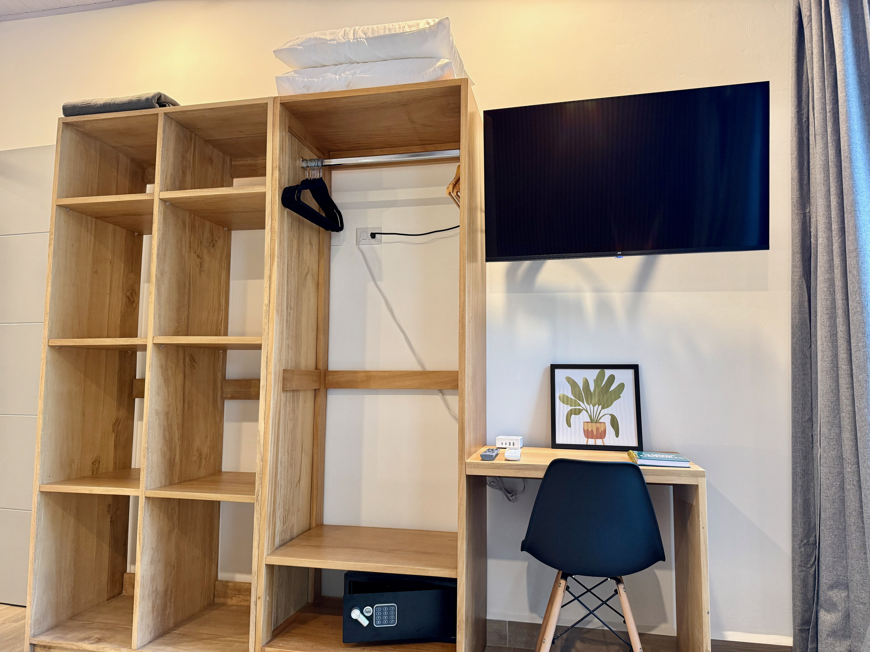 Master suite — wardrobe, integrated workspace with chair, wall TV, and safe.