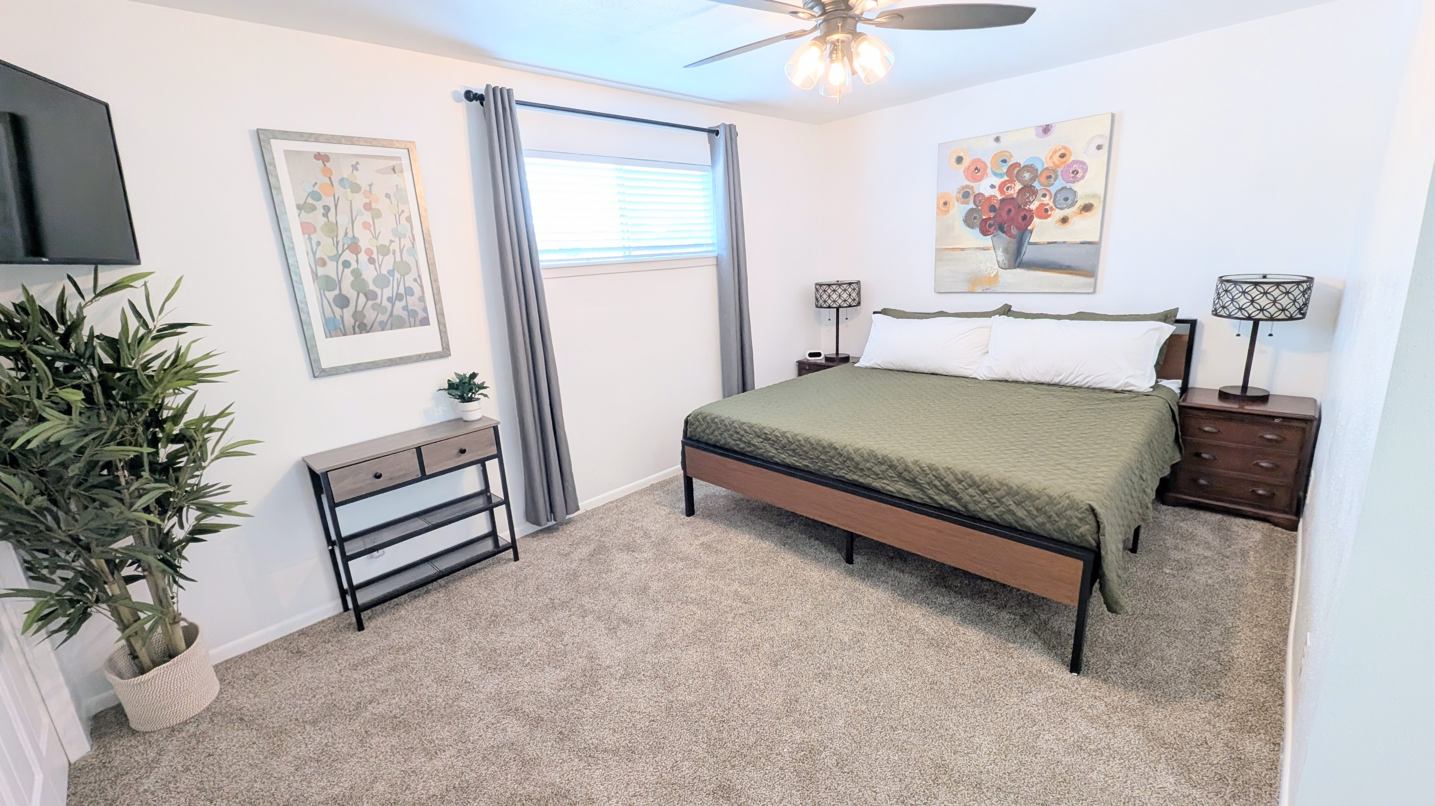 King bedroom has blackout curtains, ceiling fan, charging stations, Roku TV, closet space, and plenty of plush pillows and bedding. 