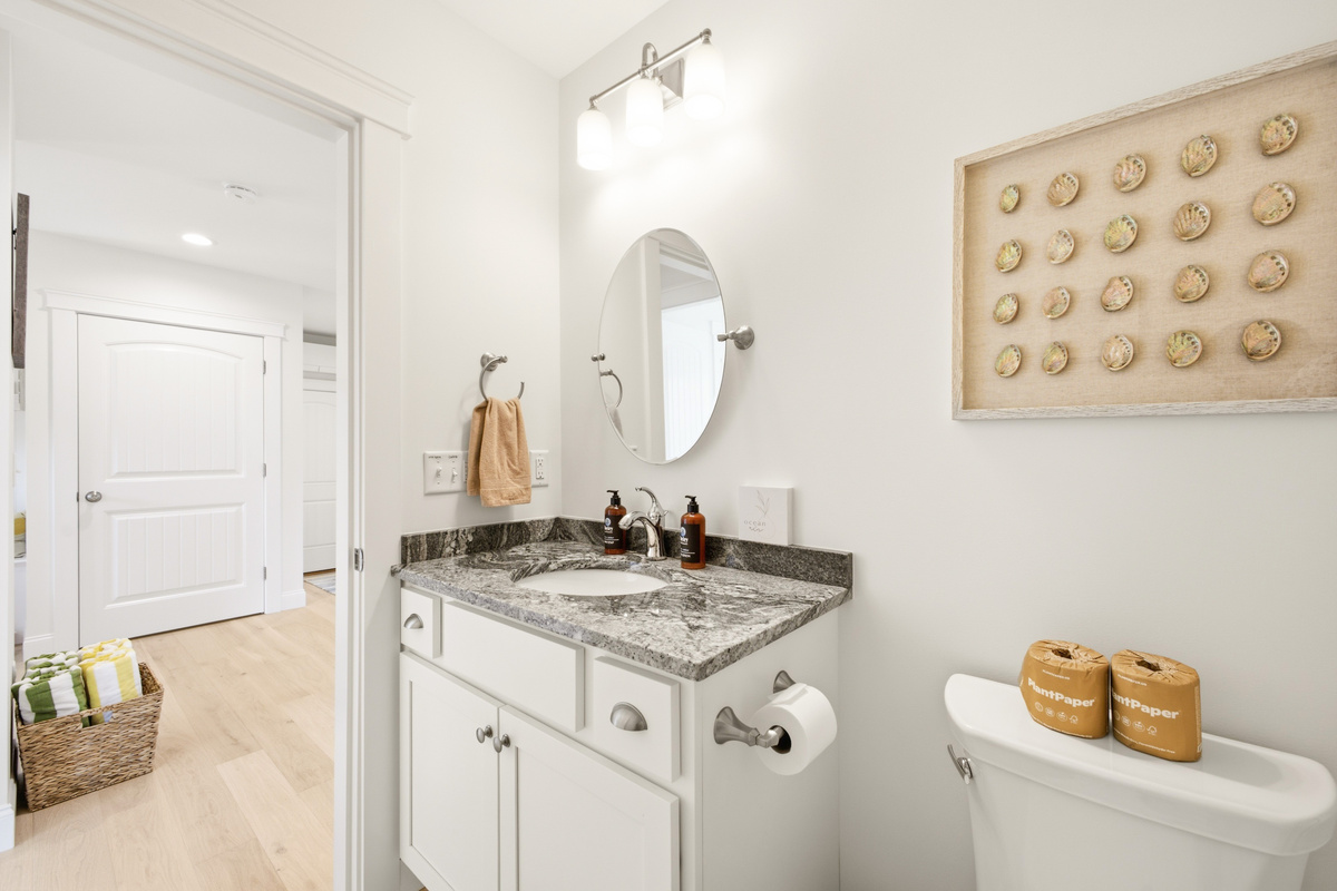 Bright, stylish bathroom featuring a granite-top vanity, vessel sink, modern fixtures, and thoughtfully selected décor.