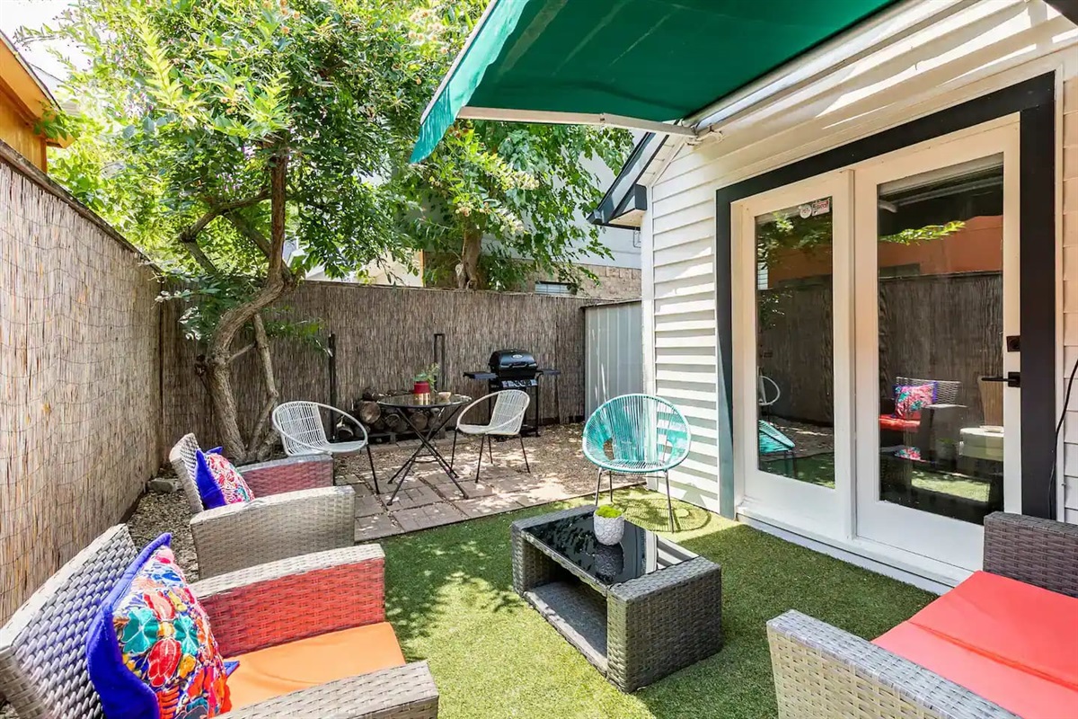Fenced backyard with shaded seating and outdoor lounge area.