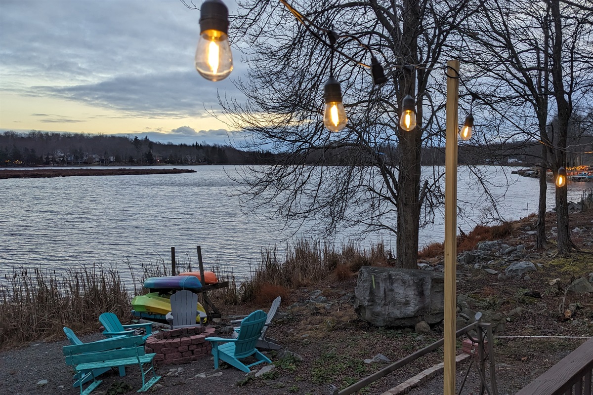 Evening view of the lake from the wooden deck enhanced with string lights
