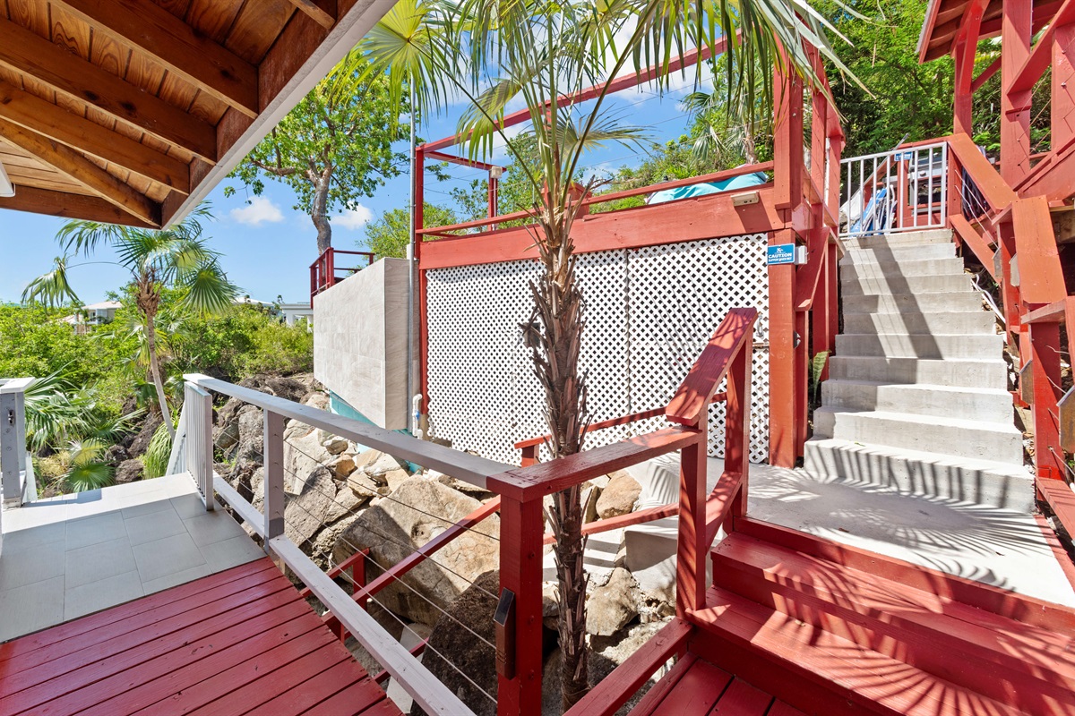 The stairs that lead up to the pool deck from the wrap around deck of the main house.
