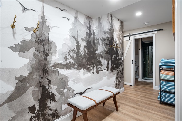A peaceful transition space with a watercolor forest mural — the perfect spot to drop your gear and unwind.