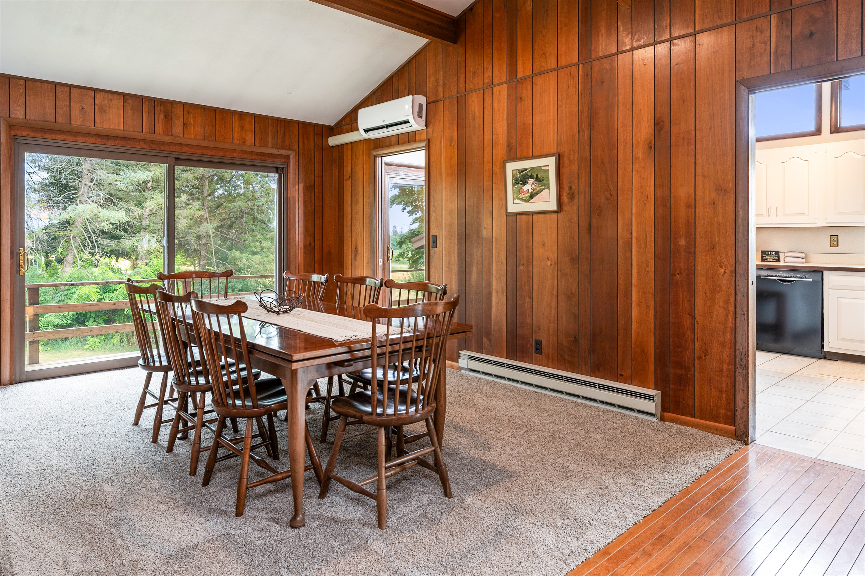 Enjoy cozy dinners by the stunning stone fireplace in this open-concept dining space, blending rustic charm with modern comfort.