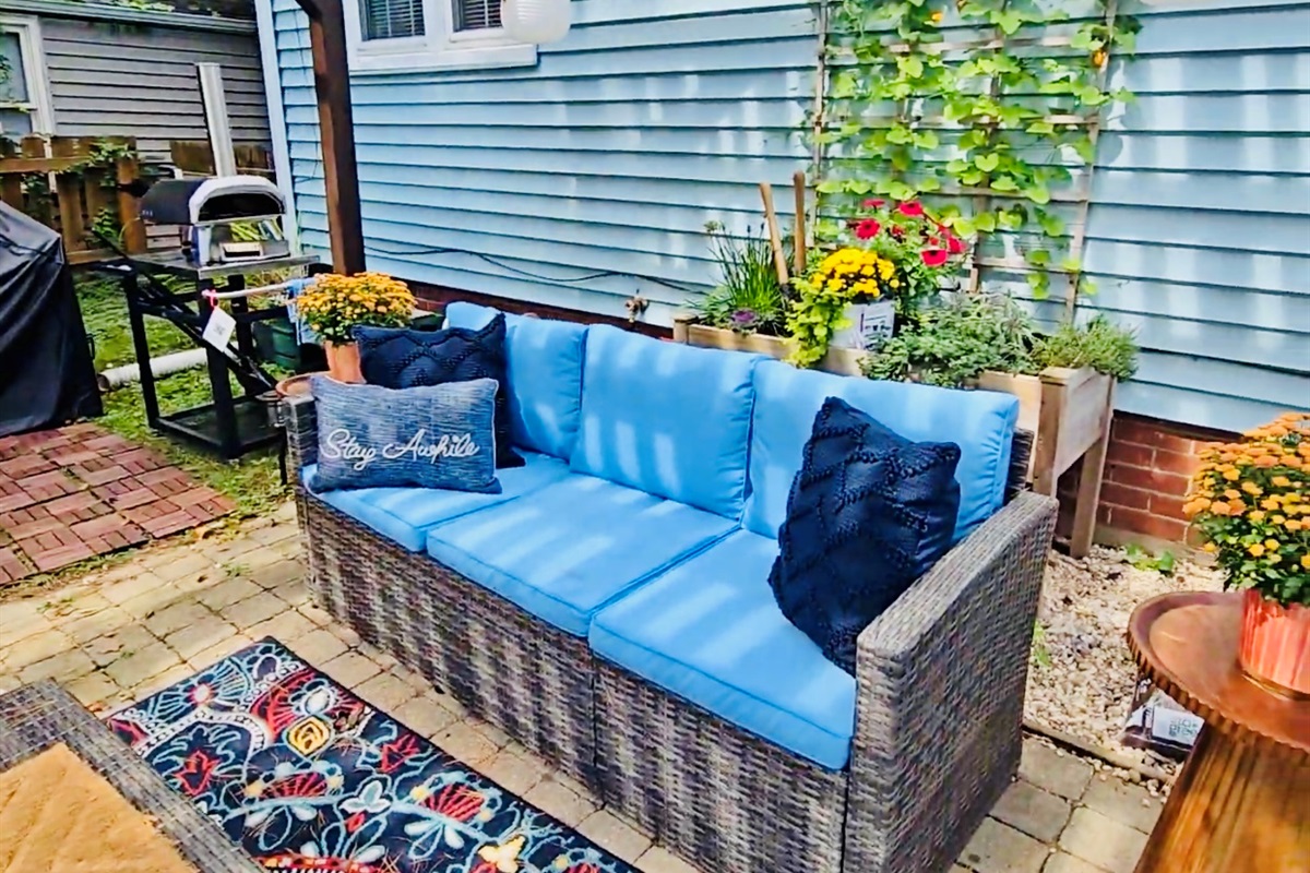 Lounge in shaded comfort beneath the pergola—our cushioned backyard sofa, dressed with inviting pillows, is just steps from the herb garden and pizza oven. It’s a cozy corner made for slow sips, shared stories, and savory moments.