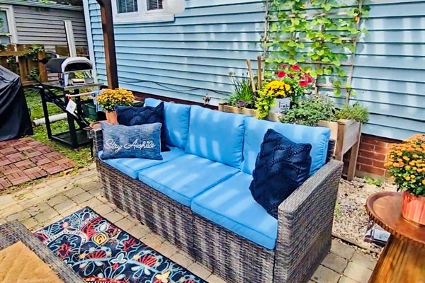 Lounge in shaded comfort beneath the pergola—our cushioned backyard sofa, dressed with inviting pillows, is just steps from the herb garden and pizza oven. It’s a cozy corner made for slow sips, shared stories, and savory moments.