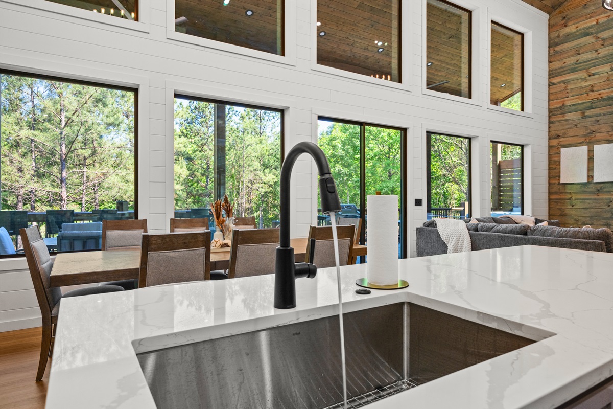 Natural light pours across the farmhouse sink and countertops, creating a bright and cheerful space to prepare meals.