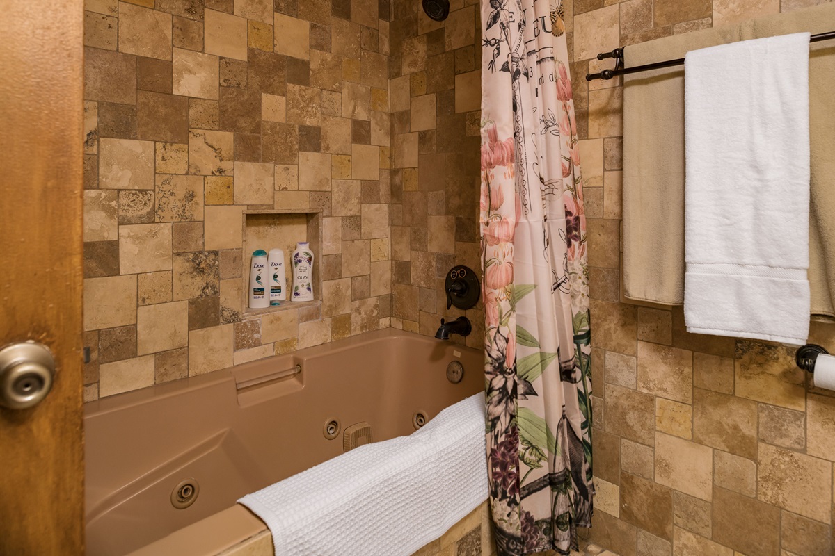 Slip behind the floral curtain into a romantic jetted tub perfect for evening unwinds and candlelit soaks.
