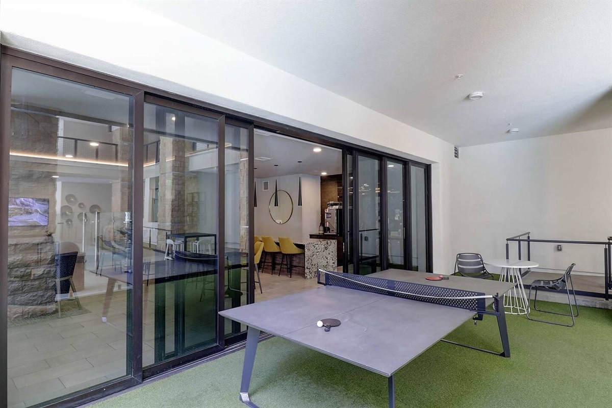 - Have fun with friends in the recreation space featuring ping pong and seating   - Large glass doors open to indoor and outdoor lounging for a relaxed vibe   - Perfect for socializing, gaming, or unwinding after a day of exploring nearby