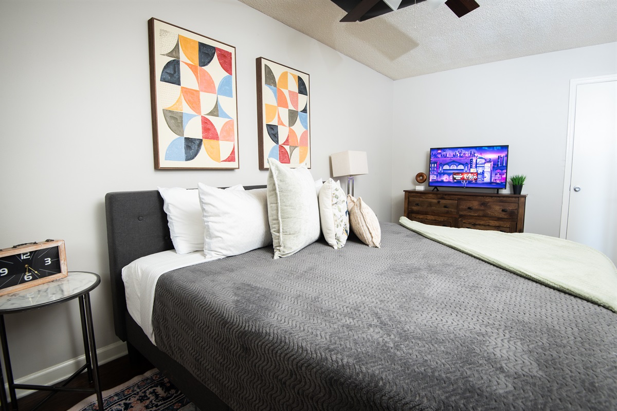 This wide shot of the single king bedroom shows a better view of the location of the smart TV.