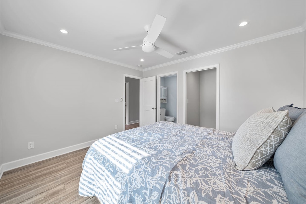 Master bedroom of Unit A with a queen bed and half bathroom. 
