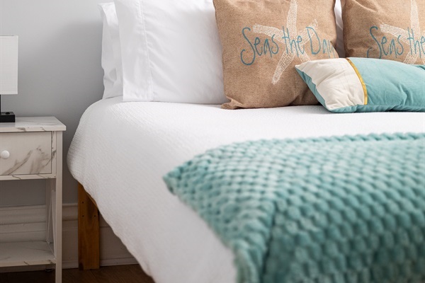 This spacious main-floor bedroom offers serene seaside vibes, featuring a queen-sized bed and a twin-over-twin bunk bed with a pull-out trundle. Your perfect coastal getaway awaits!