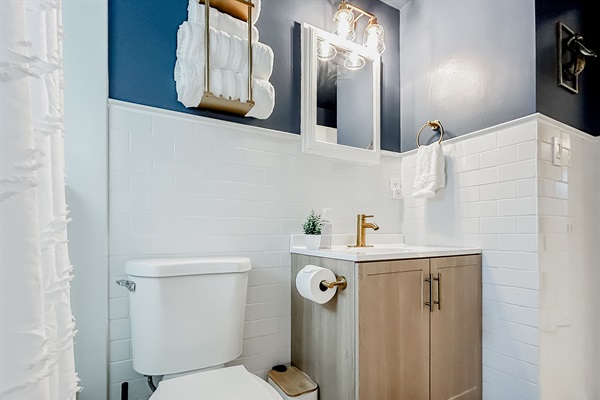 Full Bathroom with Shower, Toilet, Vanity, Towels, Mirror, & More