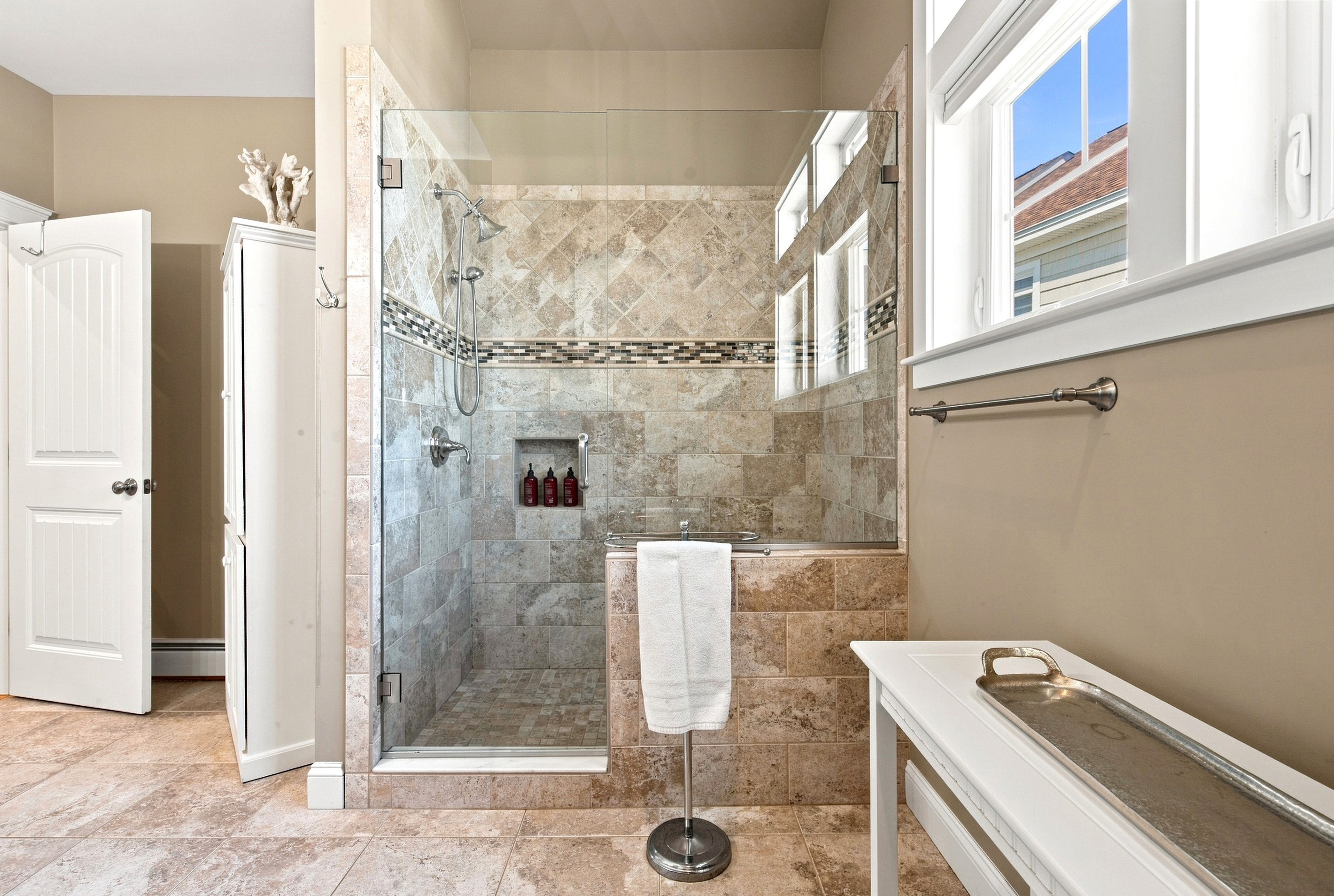 Refresh after a day at the beach in this beautifully tiled walk-in shower.