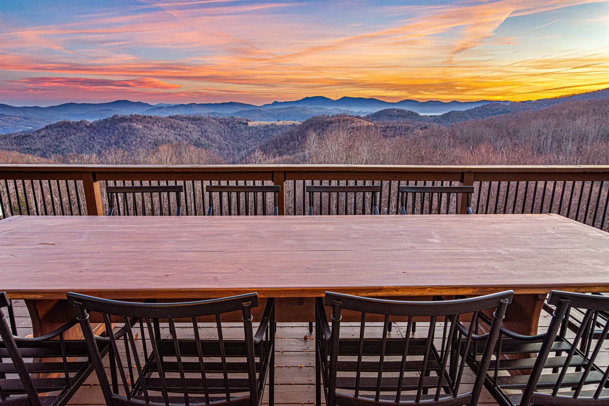 Gorgeous, large table situated directly across the original fireplace on the old side of the home overlooking layered mountain ridges at sunset.
