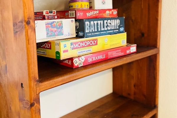 A collection of board games and puzzles lines the bookshelf, inviting creativity, friendly competition, and cozy moments indoors for all ages.