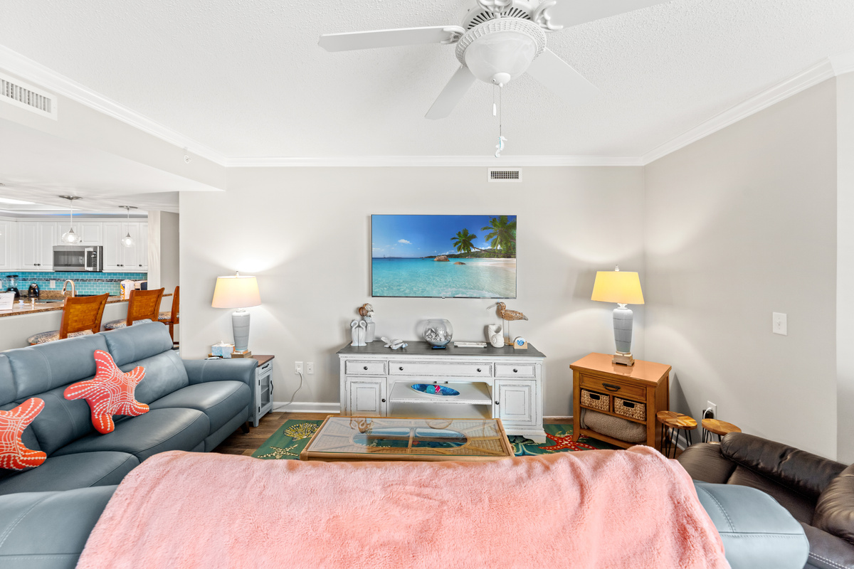 Living room are with plenty of seating and large TV with balcony access