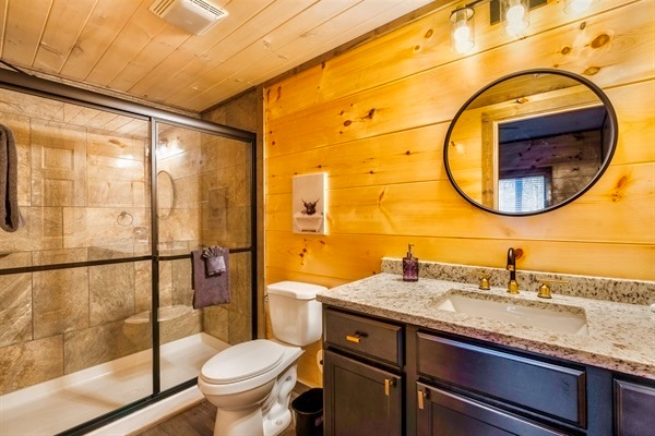 Comfortable walk-in shower with modern glass doors, complemented by luxurious bath products and elegant fixtures for a spa-like experience.