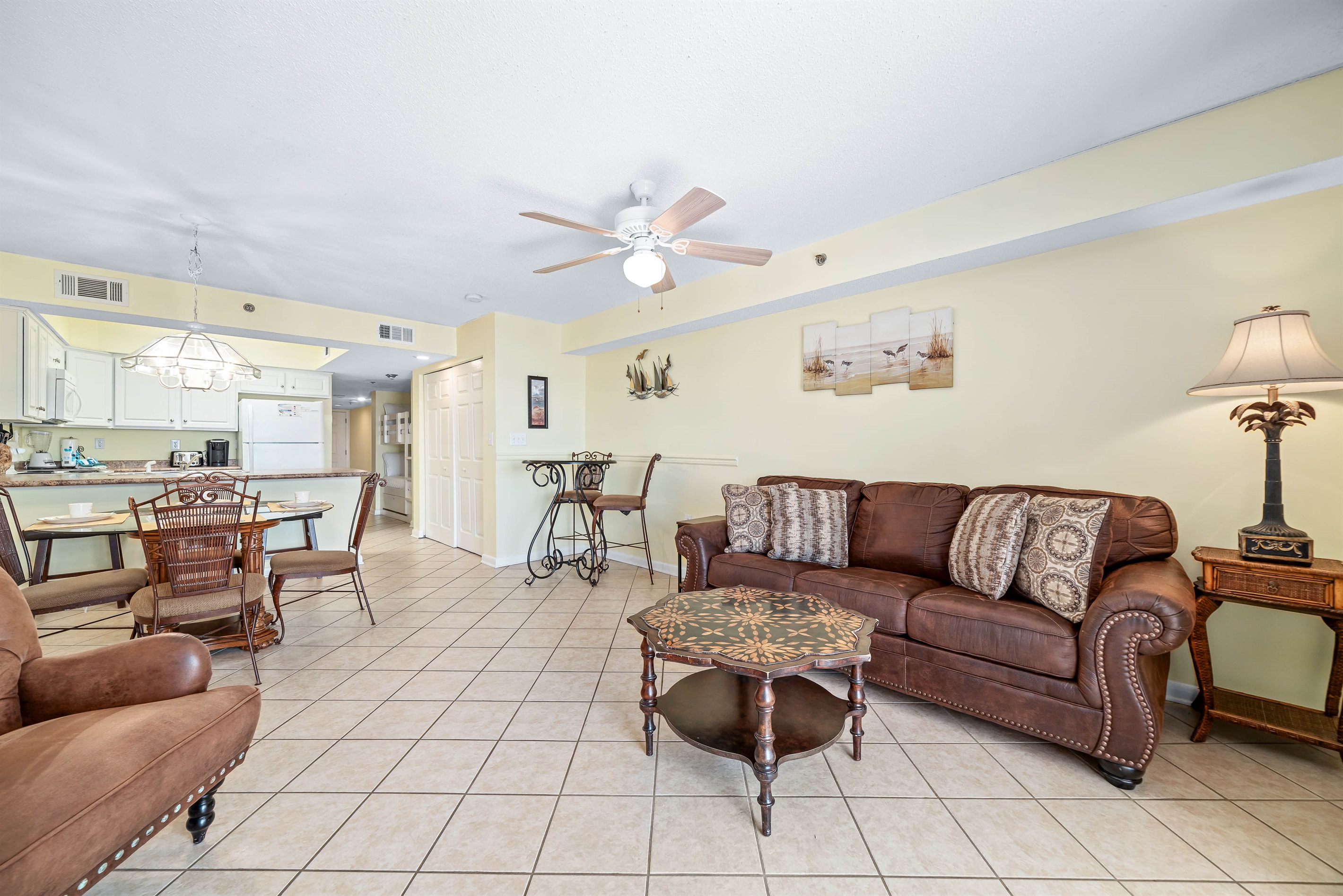 This well-appointed living space offers a comfortable sleeper sofa, elegant coffee table, and a dining area with seating for four, creating a welcoming atmosphere.