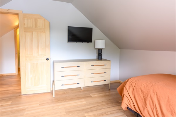 a large dresser and a 32 inch smart tv.