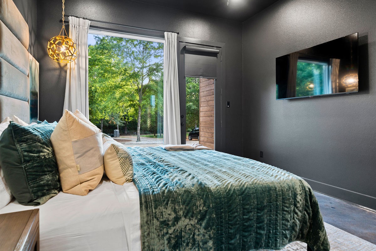 Floor-to-ceiling windows provide breathtaking views of the lush greenery outside, bringing a serene and calming atmosphere into the room.