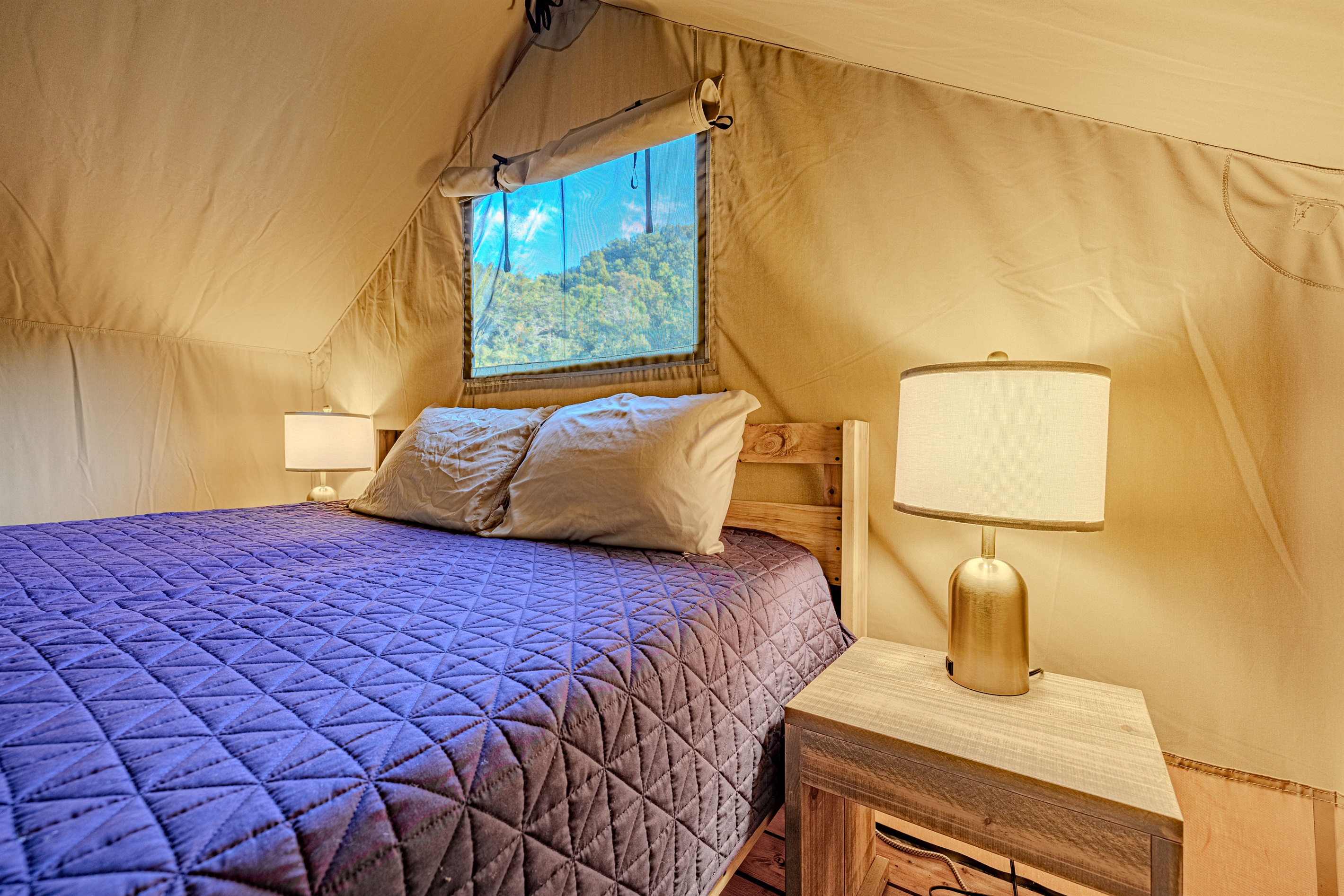 Your cozy centerpiece. Sink into this inviting bed after a day of exploring. Notice the stylish bedside lamps offering warm, ambient light.