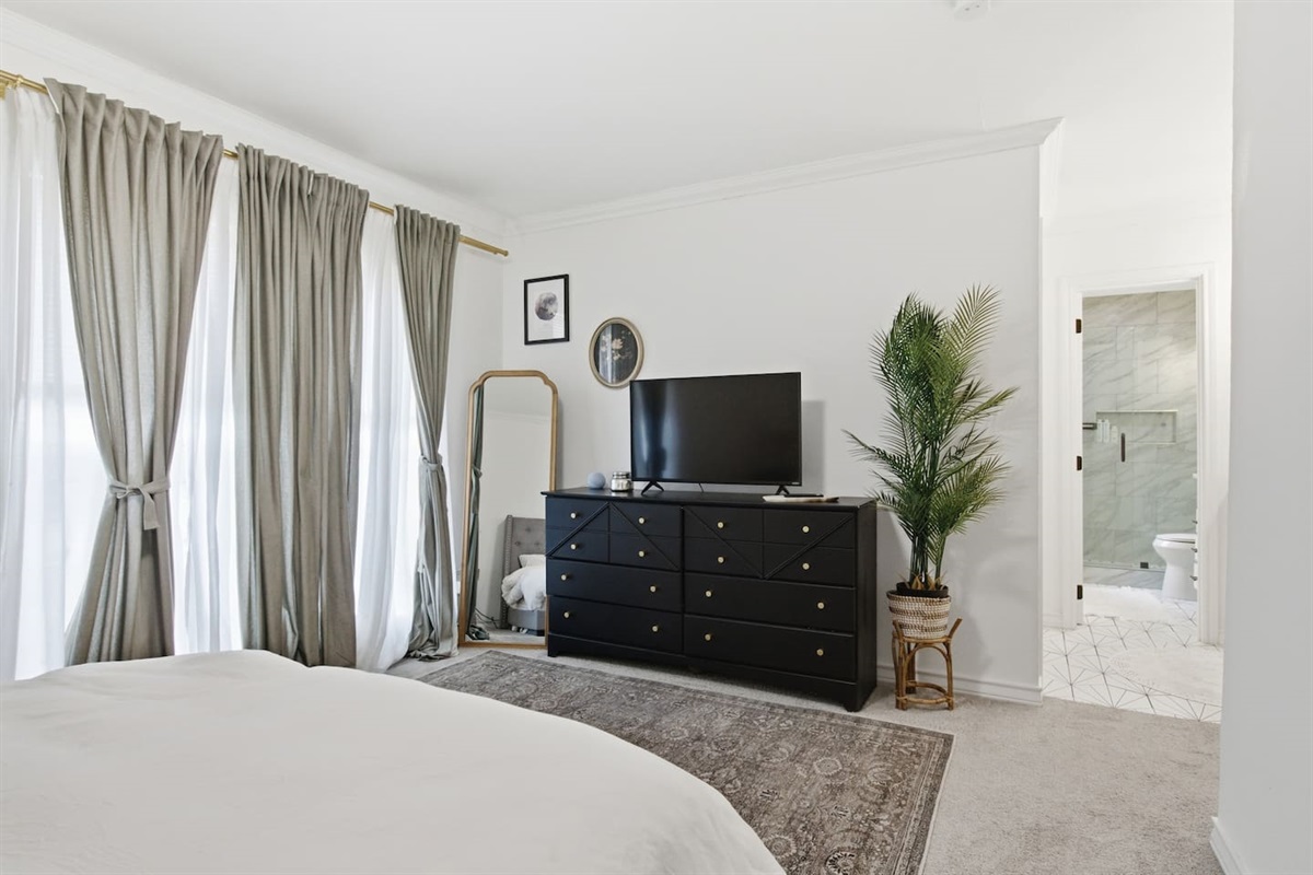Primary bedroom with Smart TV, dresser storage, fast WiFi, and room darkening shades for a peaceful stay.