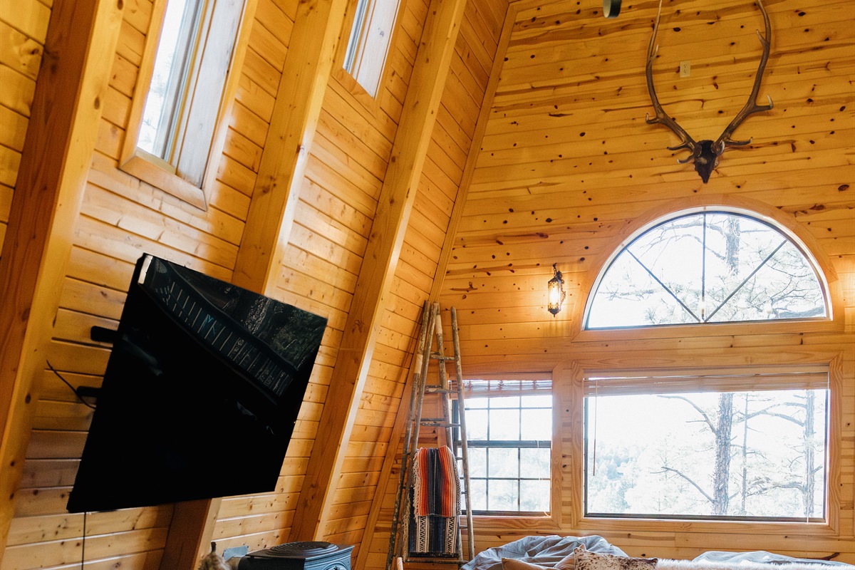 Dramatic A-frame architecture floods Poppywood Pines with natural light from soaring windows. This unique gothic western Show Low cabin features cozy furnishings and authentic decor, creating your perfect White Mountains retreat near hiking, fishing, and s