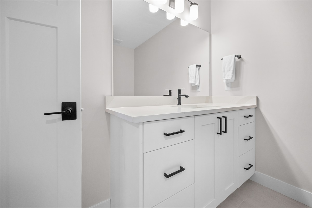 Modern ensuite vanity with contemporary fixtures and fresh linens.