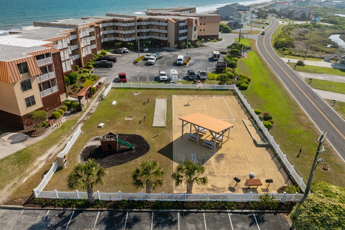 Spacious shared grounds with courts, picnic pavilion, and play area&mdash;all just steps from the beach