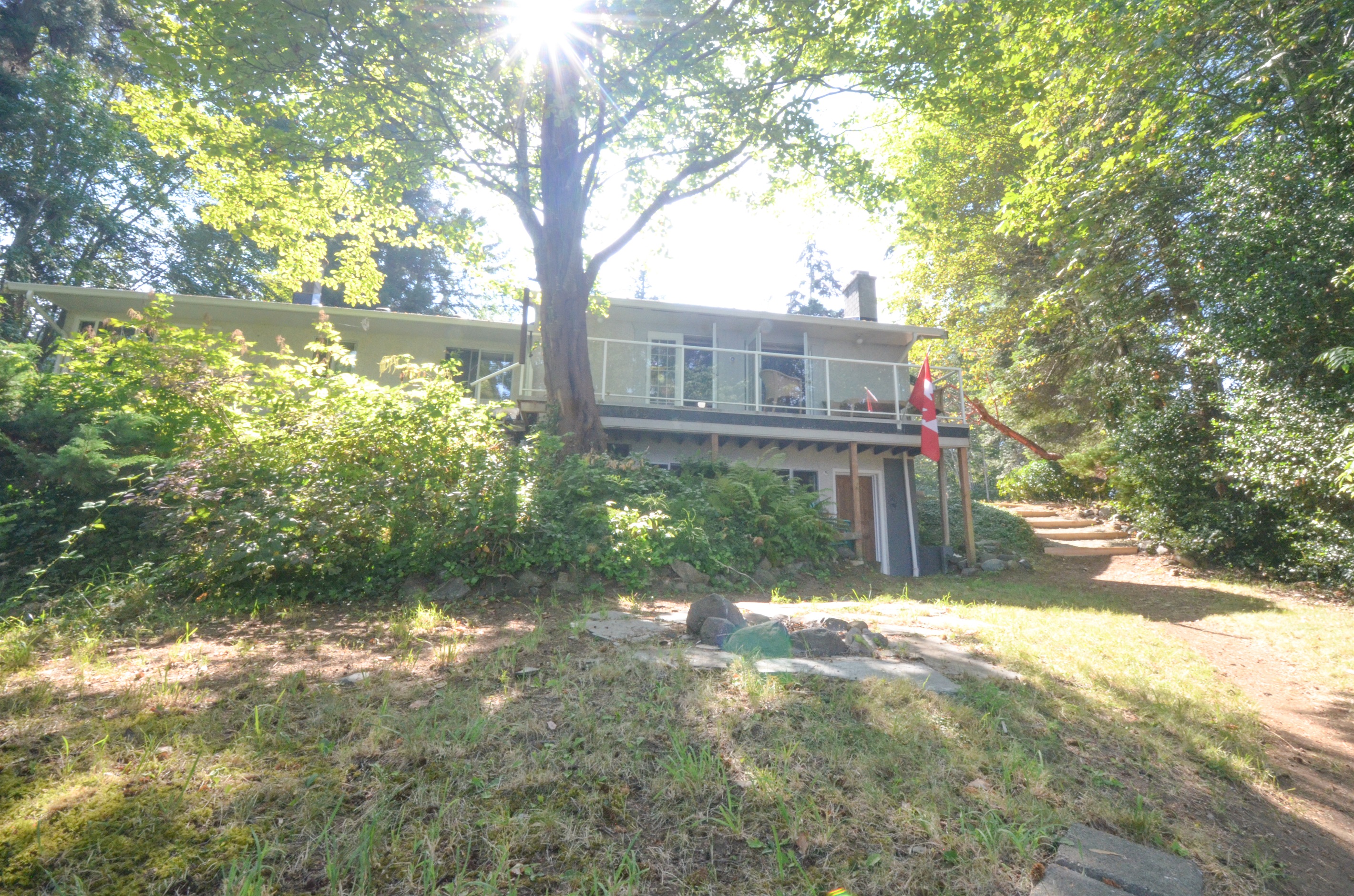 Back porch view with elevated yard above shoreline