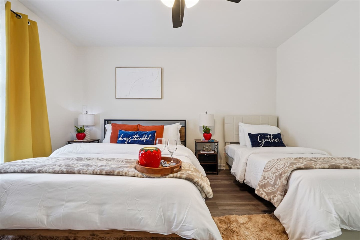 Another cozy bedroom featuring both a full bed and a twin bed, along with an Amazon Fire-powered Smart TV for your entertainment. This room includes 4 full-body towels, 4 washcloths, and 2 hand towels for your stay.