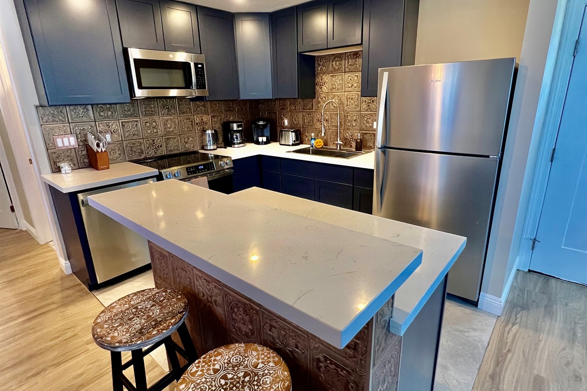 Whip up a meal in the fully-equipped modern kitchen, featuring stainless steel appliances and a stylish breakfast bar with seating for two.