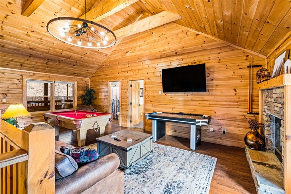 Upstairs loft game room with pool table, air hockey, arcade game, and big screen TV