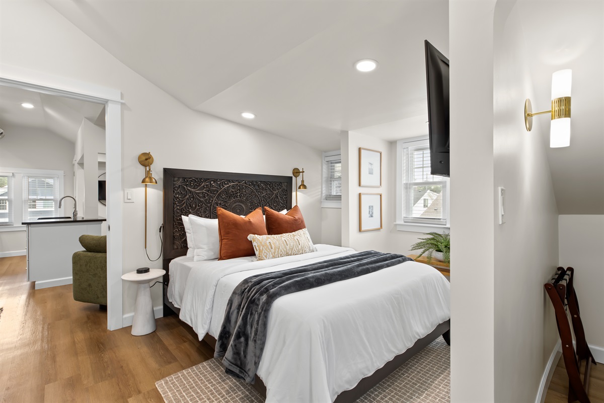 Chic bedroom suite with a comfy queen bed, curated artwork, and cozy lighting.