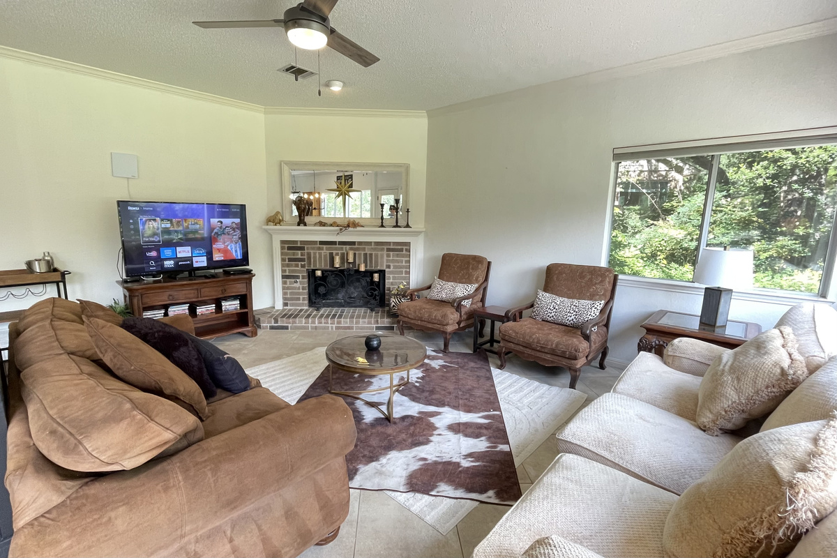 This stylish living space features generous seating,  an entertainment center that includes a 65-inch LED TV,  Roku and Apple TV for streaming, antenna for live TV, DVD player and DVDS, a beverage cart.