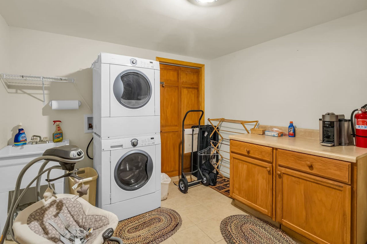 Convenient laundry area with washer/dryer, utility sink, and ample counter space for folding clothes