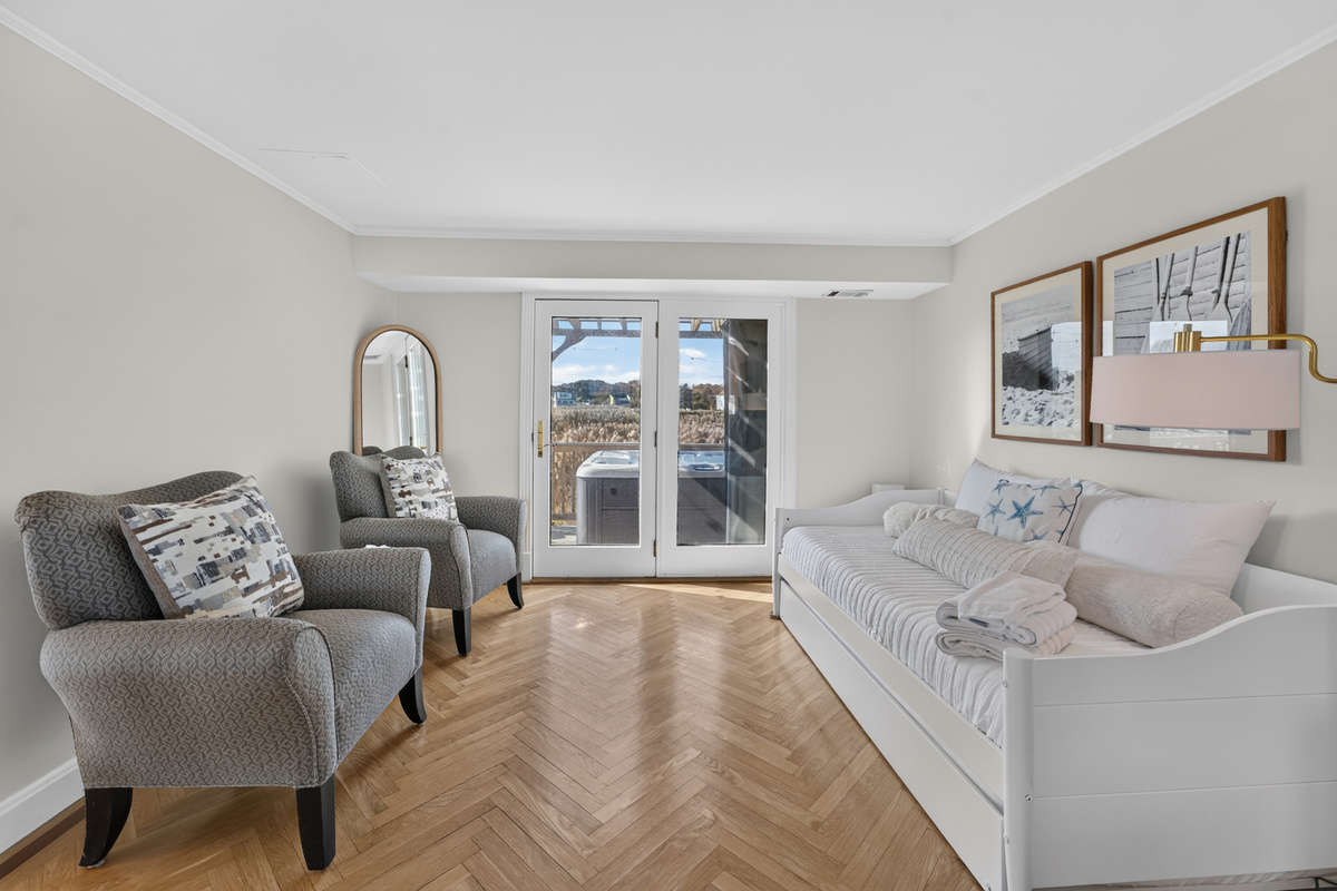 Airy bedroom with coastal décor, natural light, and comfortable sleeping accommodations.