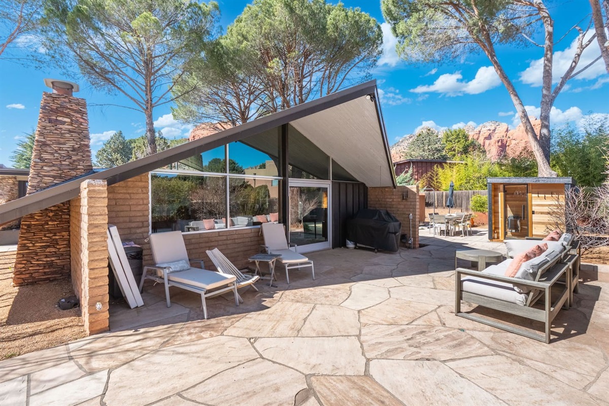 Architecturally striking mid-century retreat with dramatic rooflines, expansive glass walls, and a spacious patio designed for seamless indoor-outdoor living — all set against breathtaking red rock views.