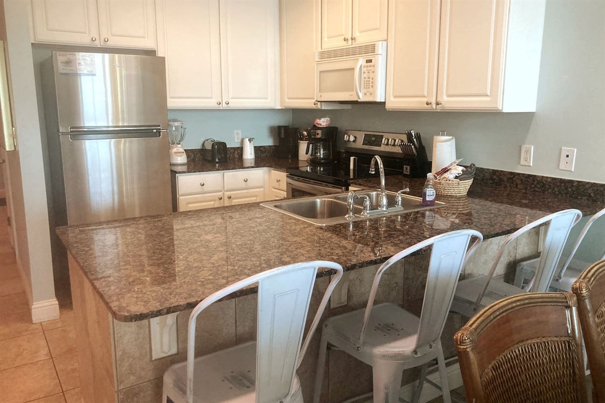 Full kitchen with dining table and bar.