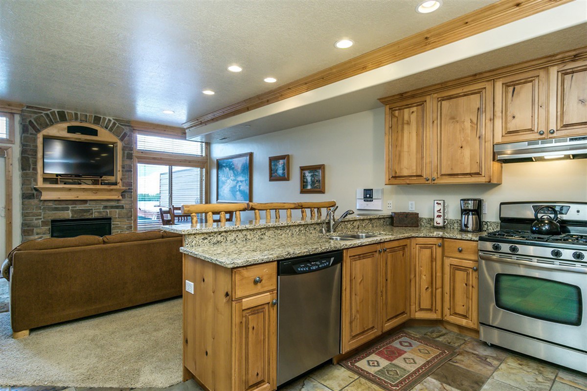 A beautifully crafted kitchen with granite countertops and rich cabinetry, blending functionality and mountain charm for effortless cooking and entertaining.