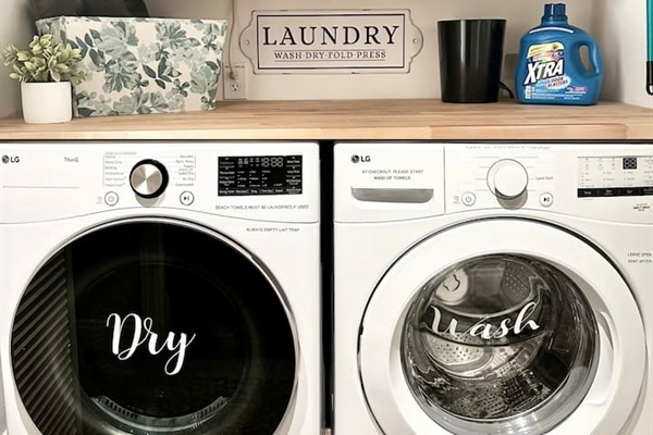 Enjoy the convenience of an in-home laundry station equipped with modern, front-loading LG appliances. This organized space includes a handy folding counter and essential supplies, making it easy to keep clothes fresh and clean during any stay.