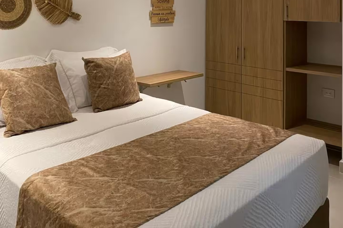 Instálate en un dormitorio tranquilo con iluminación suave, texturas cálidas y ropa de cama flexible para descansar después de un día explorando la zona.