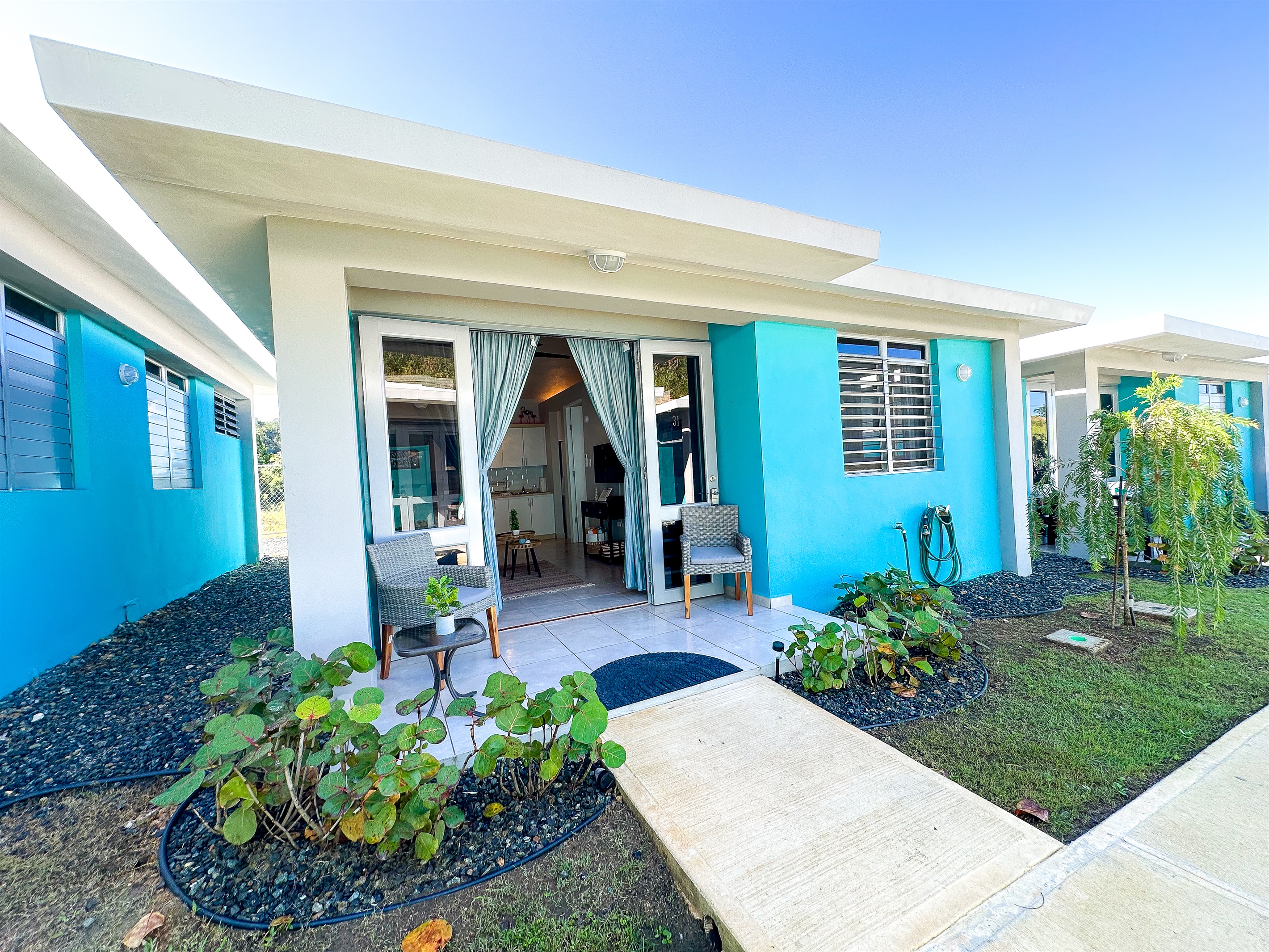 Exterior Oasis: Vibrant turquoise walls and inviting greenery create a serene getaway experience!