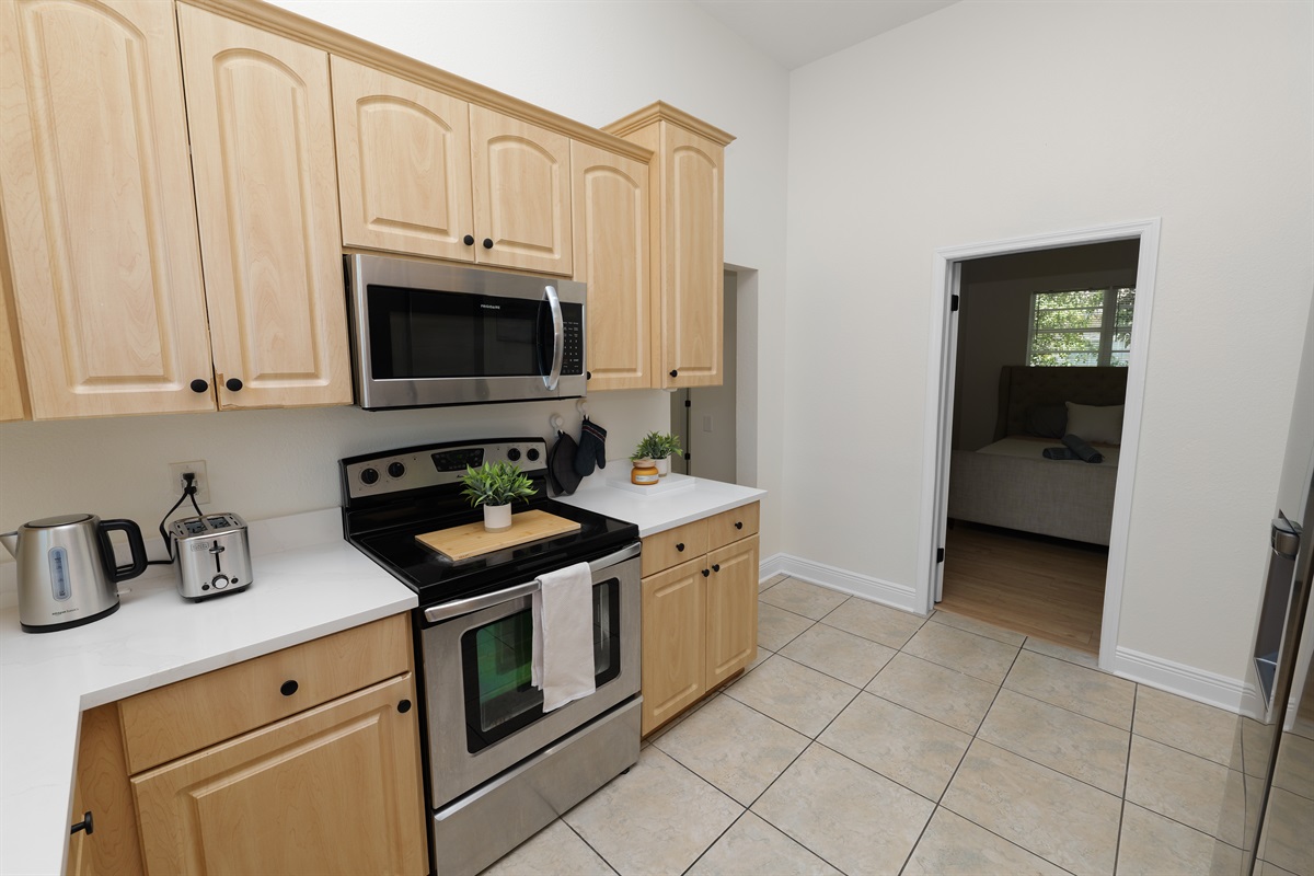 Bright and open kitchen featuring sleek appliances, ample counter space, and a warm, natural wood aesthetic.