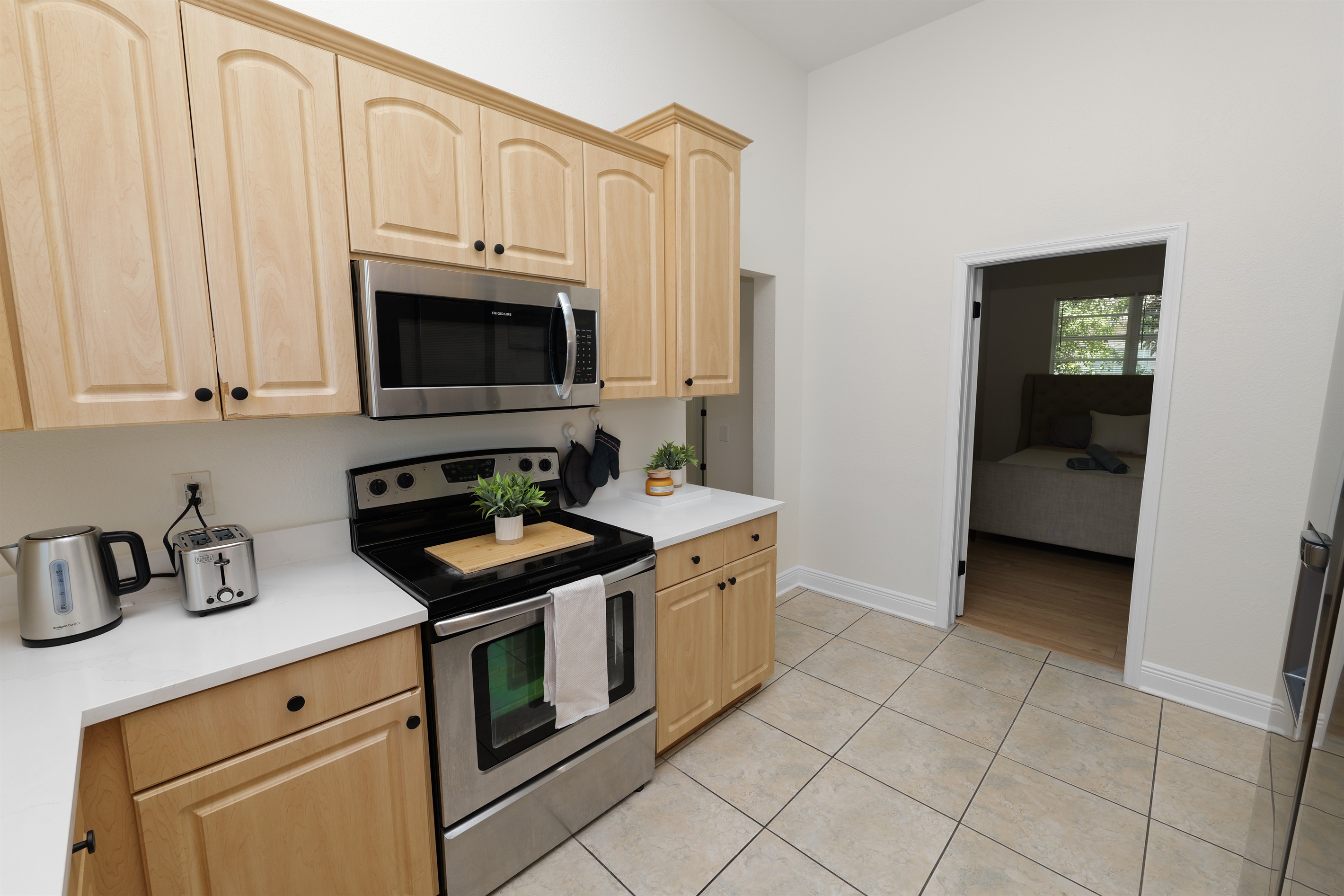 Bright and open kitchen featuring sleek appliances, ample counter space, and a warm, natural wood aesthetic.