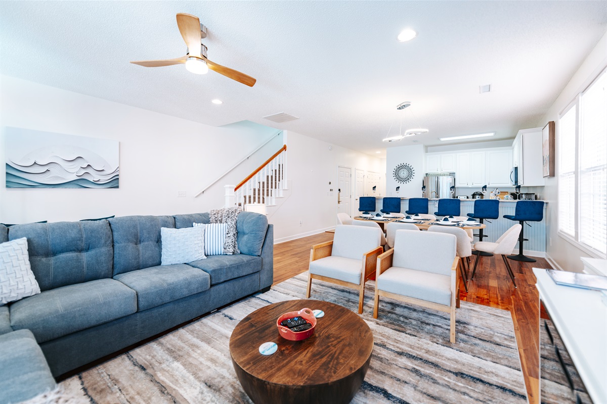 [Living Room] As you enter Seaside Paradise, you will see the open-concept living area and kitchen/dining room right away.  #openfloorplan #summerwanderlust #BeachBliss #cozyspaces #fireplace #TV