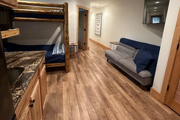 Lower level of the cabin with bunk bed & sofa
This area also has a sink, fridge, & cabinet space.