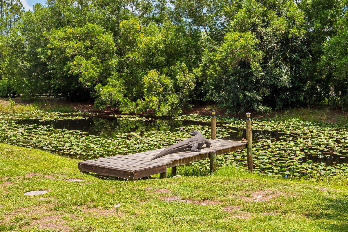 Expansive backyard retreat featuring a wood firepit, lush greenery, and a private pond perfect for fishing, offering a serene and secluded outdoor escape.
