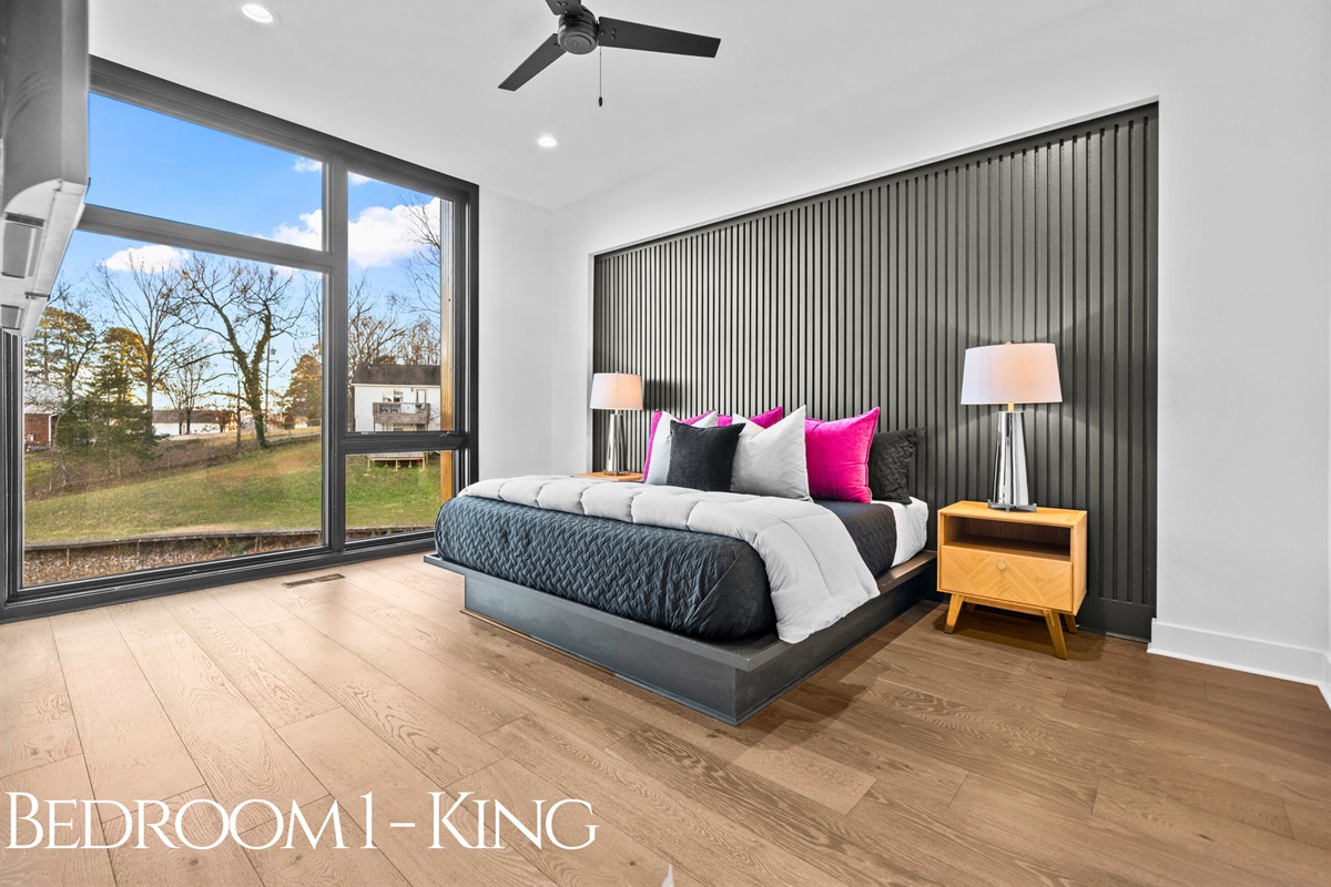 A luxurious king bedroom with bold color accents, inviting textures, and large windows that let in natural light and serene outdoor views.